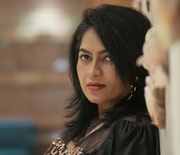 Portrait of Reena in a black outfit with gold sequins